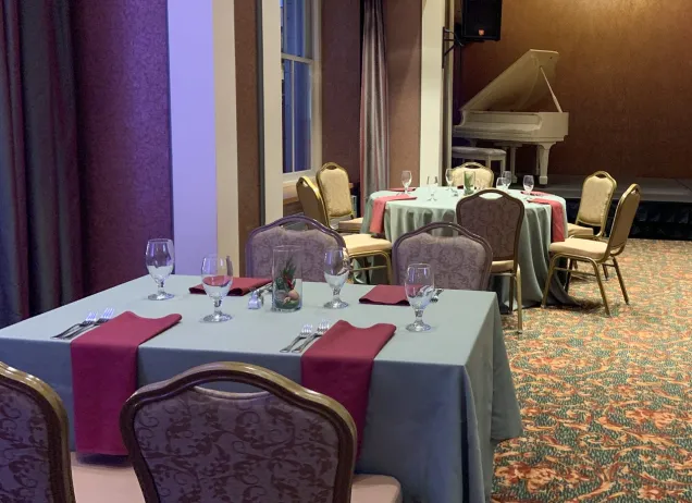 dining room setup with white piano in background